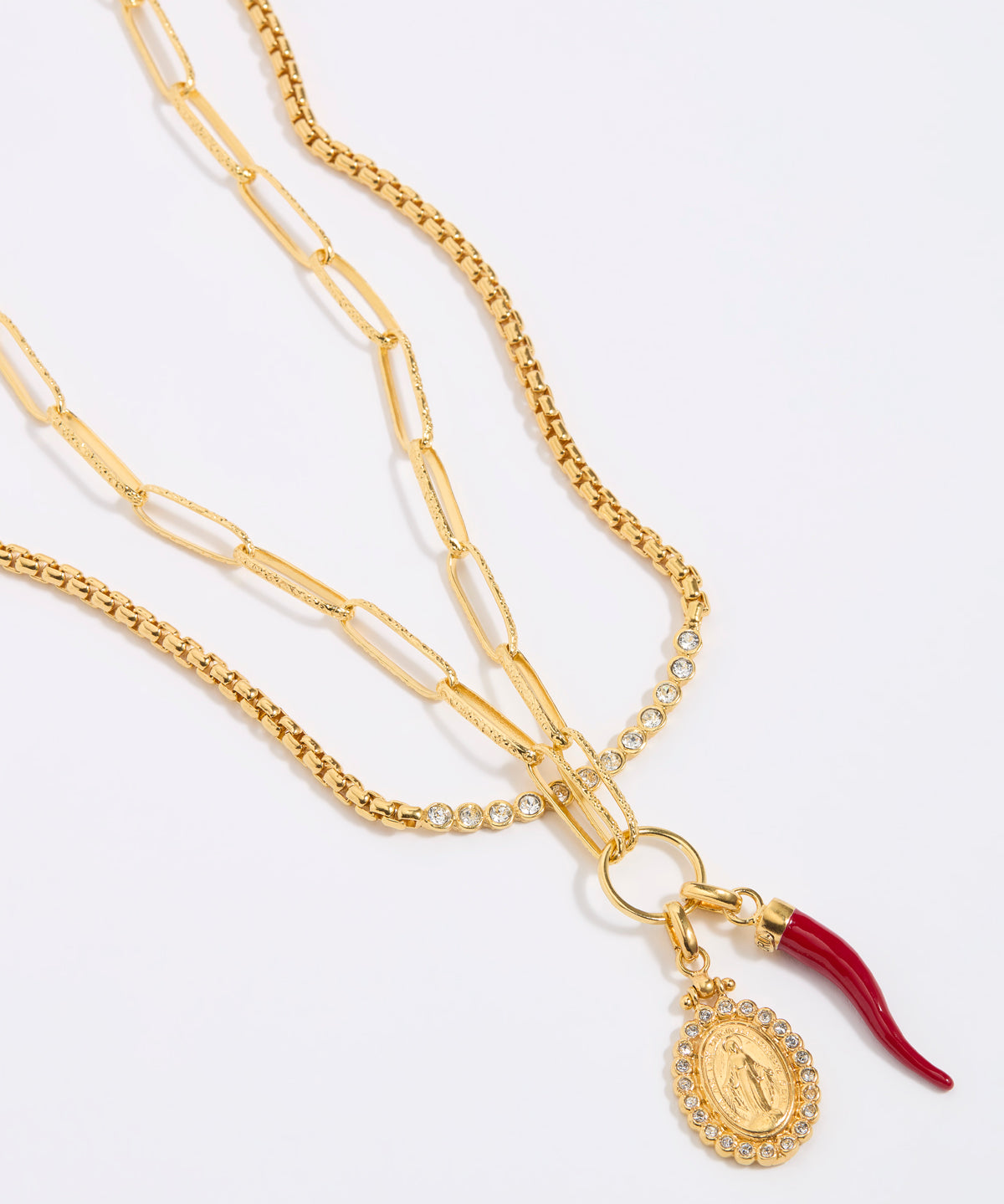 Gold necklace with a pendant and red accent on a white background