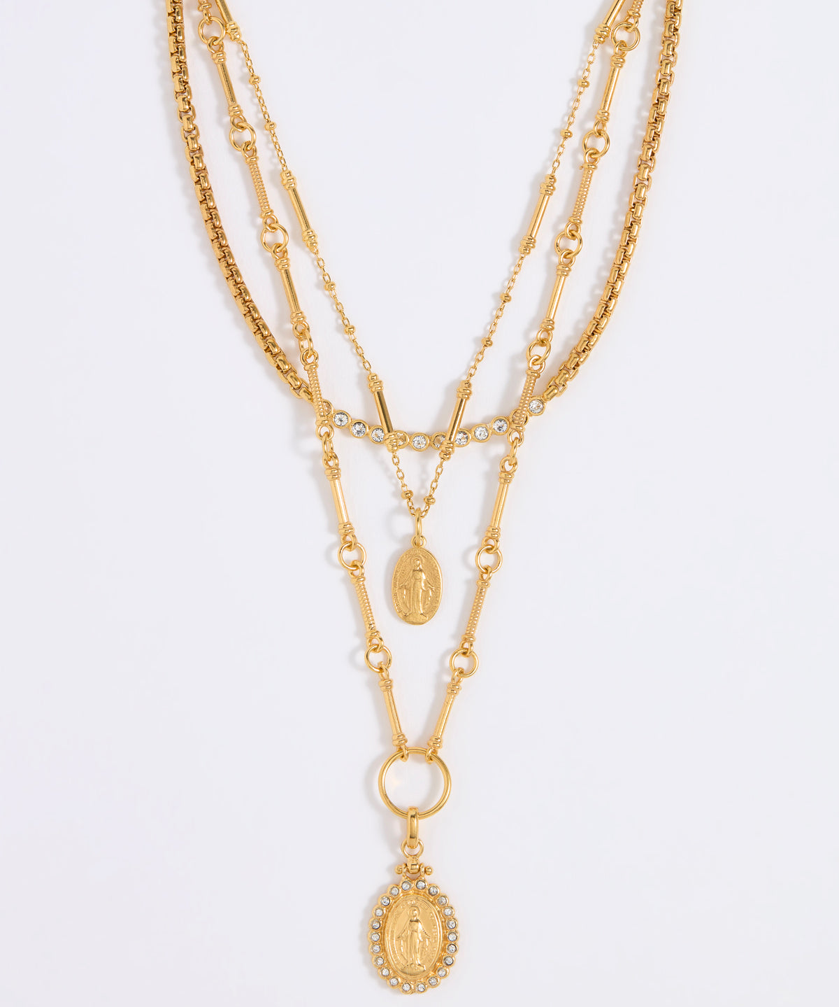 Gold layered necklace on a light gray background