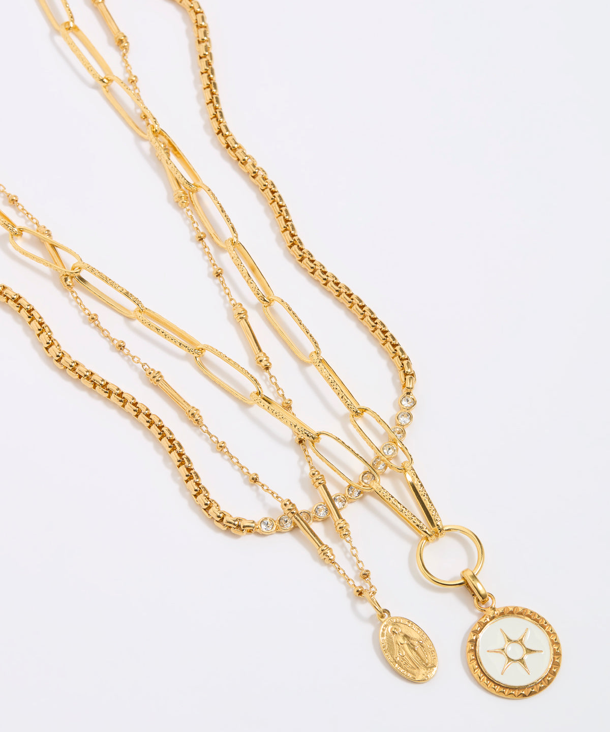 Set of gold necklaces with various links and pendants on a light gray background
