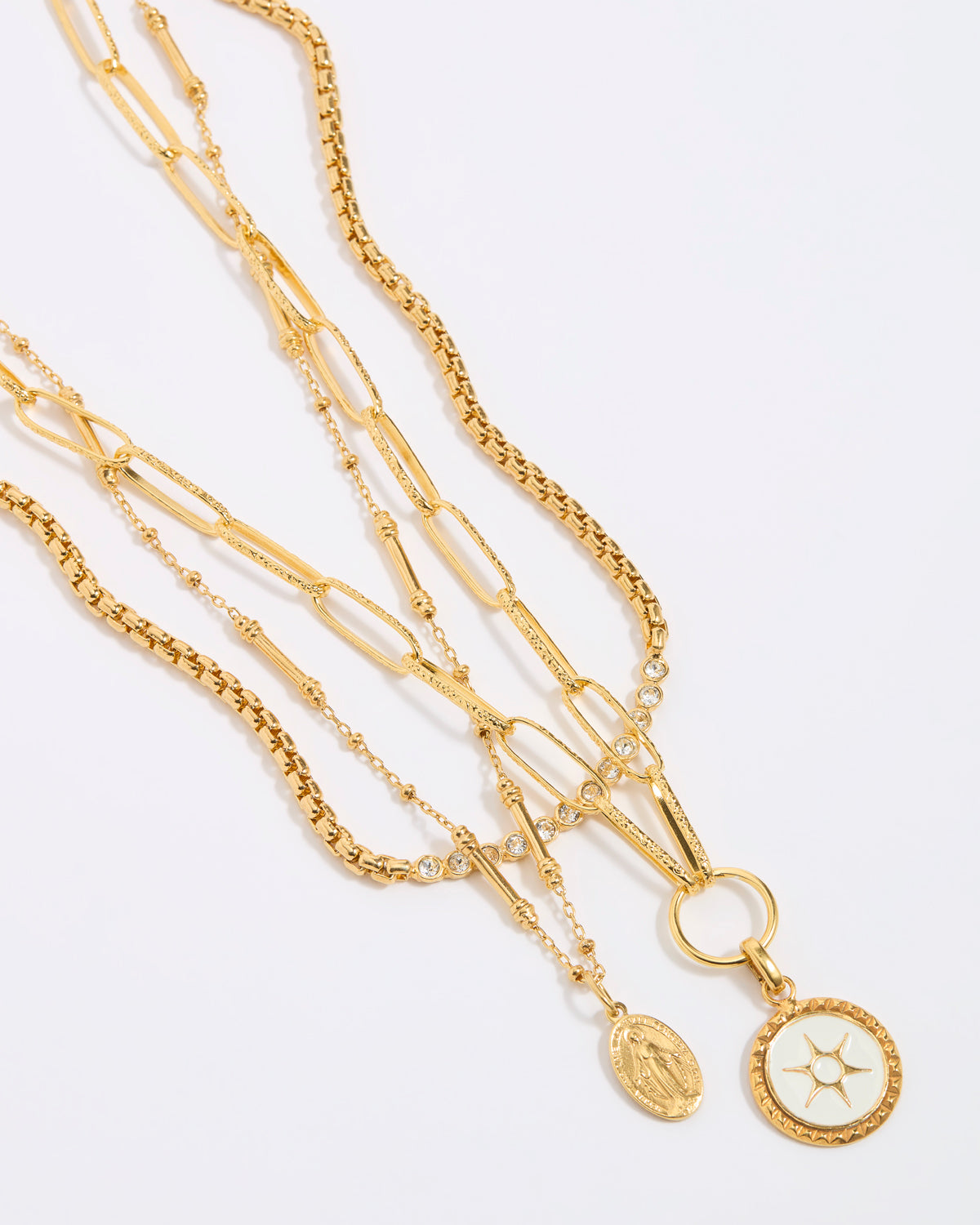 Set of gold necklaces with various links and pendants on a light gray background