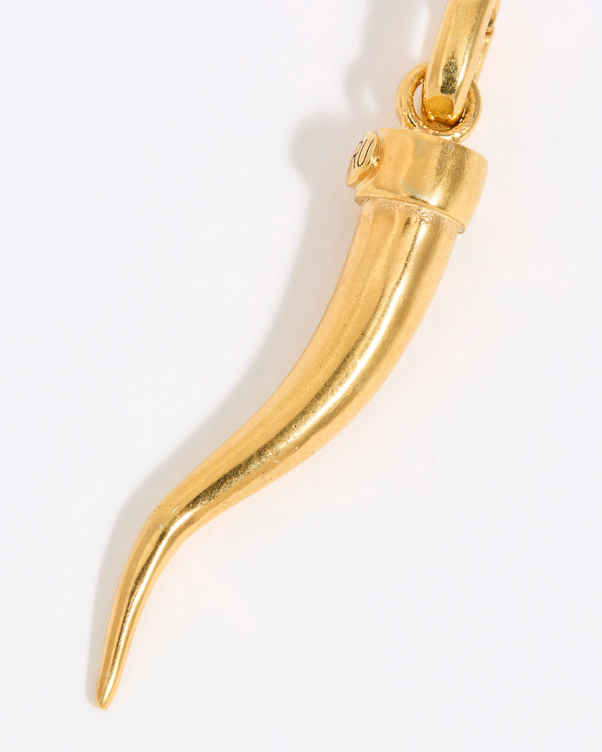 Gold horn-shaped cornicello pendant on a white background