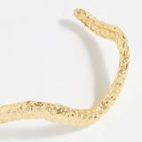 close up of textured curved gold bracelet cuff