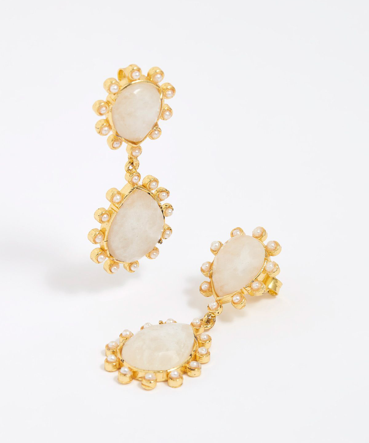 Close up product shot of gold earrings with teardrop shaped moonstones and small pearls on  white background