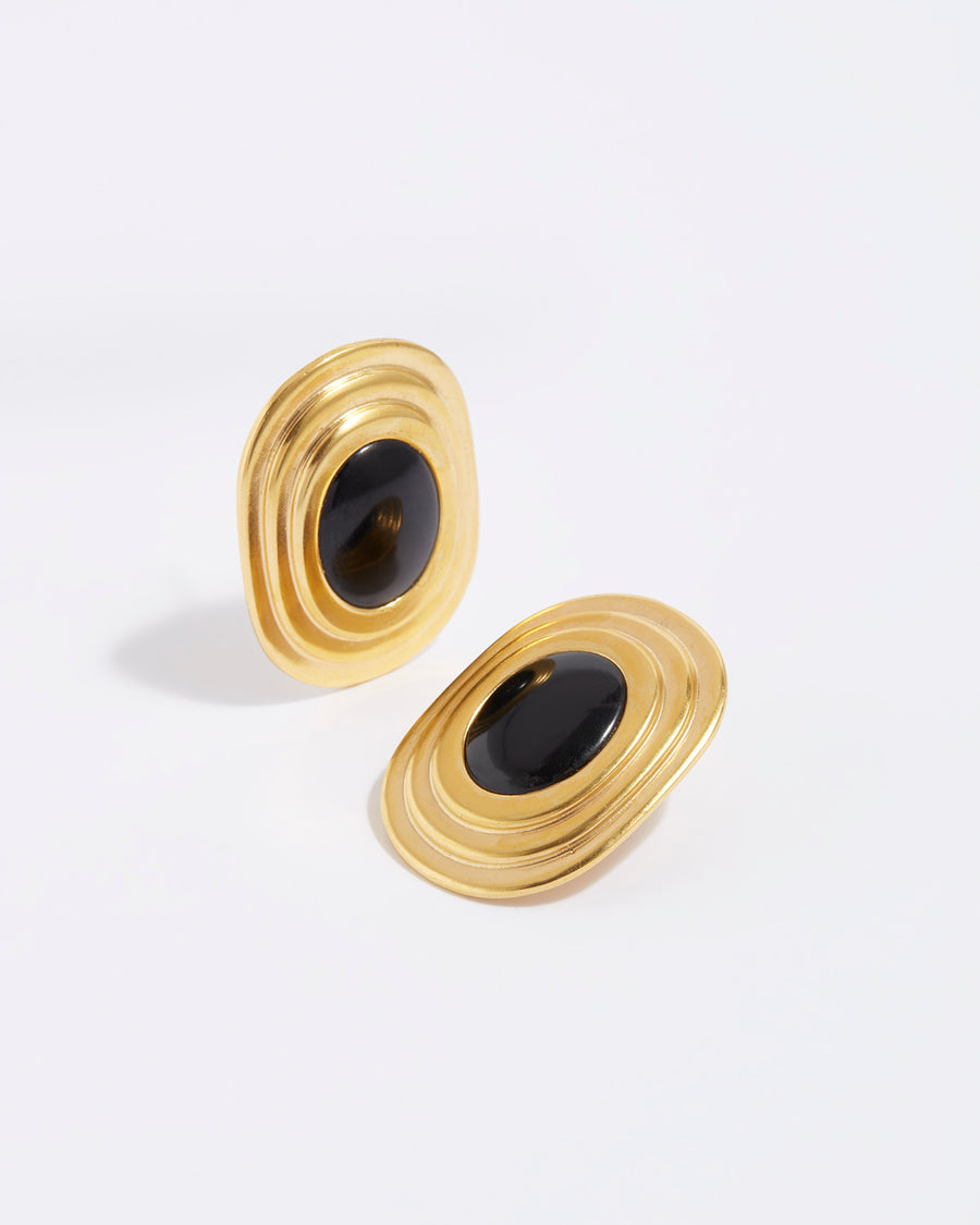product shot of oversized gold plated silver stud earrings with oval black onyx centre
