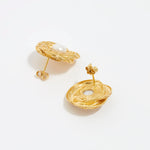 close up image shot of side and reverse view of round gold textured earrings with centre pearl on a white back ground