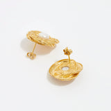close up image shot of side and reverse view of round gold textured earrings with centre pearl on a white back ground