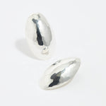 product shot of oversized textured silver oval earrings on a white background