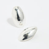 product shot of oversized textured silver oval earrings on a white background