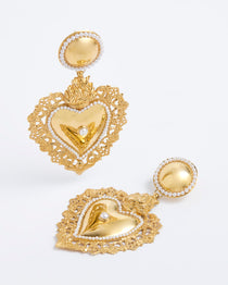 Product shot of gold traditional burning heart statement earrings with pearl detailing.
