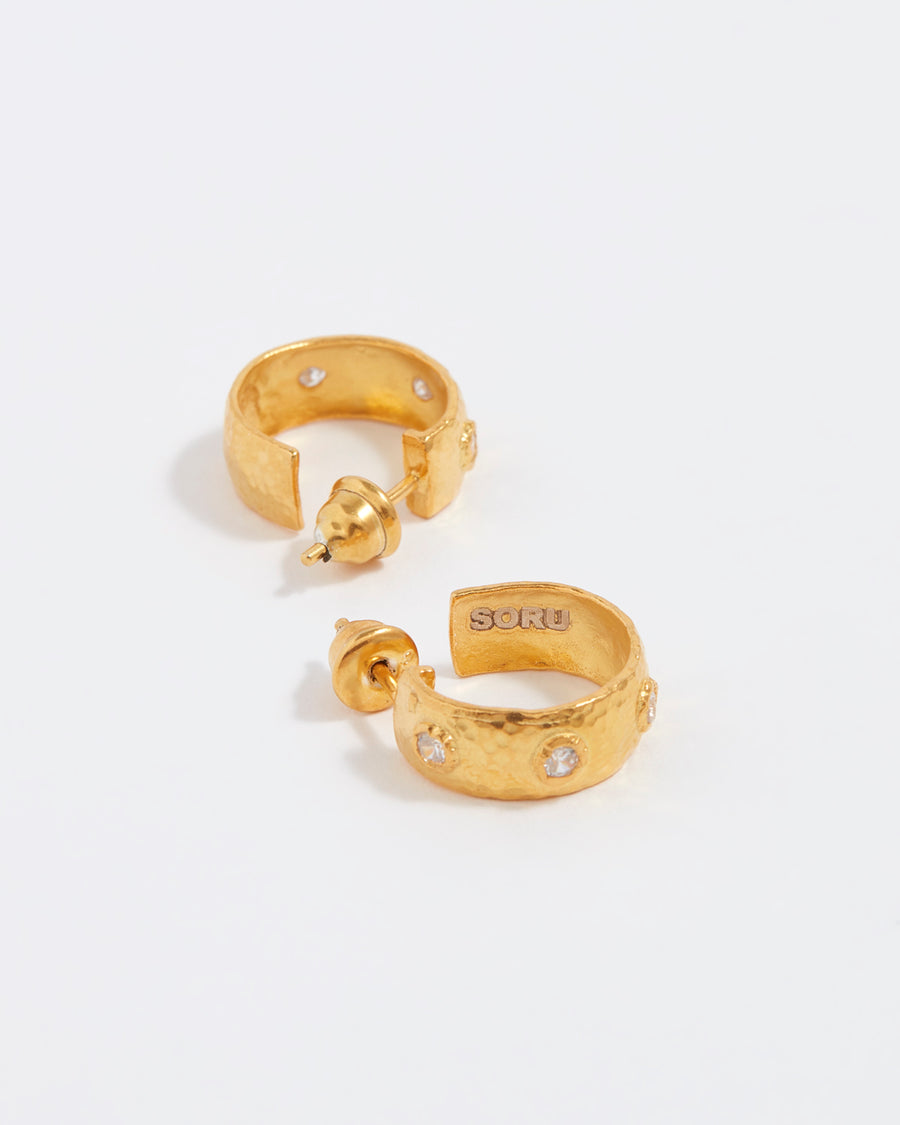 image shows inside of small gold hammered crystal hoops with logo inside