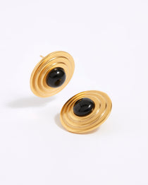 Product shot of gold plated silver and onyx disc stud earrings on a white background.