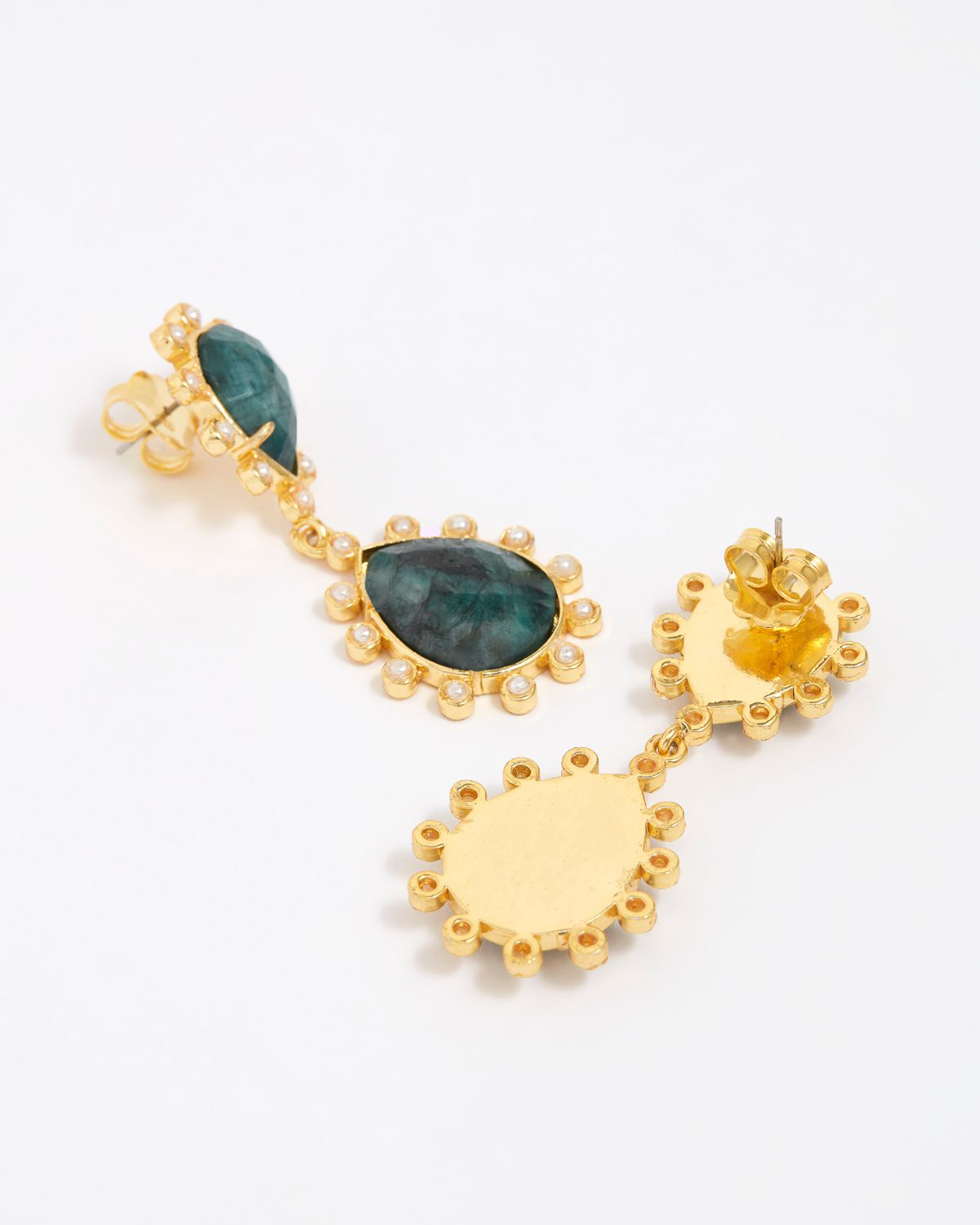 Close up of side and reverse product shot of gold earrings with green gemstones on a white background.
