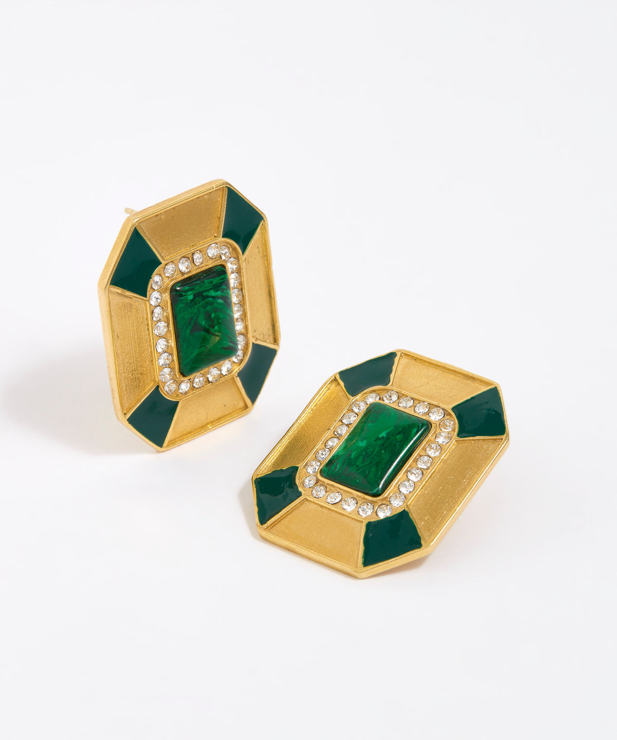 Close up image shot of statement gold and green malachite earrings with clear crystal embellished on a white background