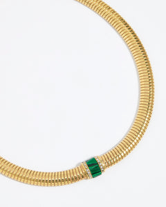 Gold chunky necklace with a green malachite gemstone embellished with clear crystals on a white background