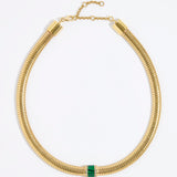 Gold chunky necklace with a central green malachite gemstone embellished with clear crystals on a white background