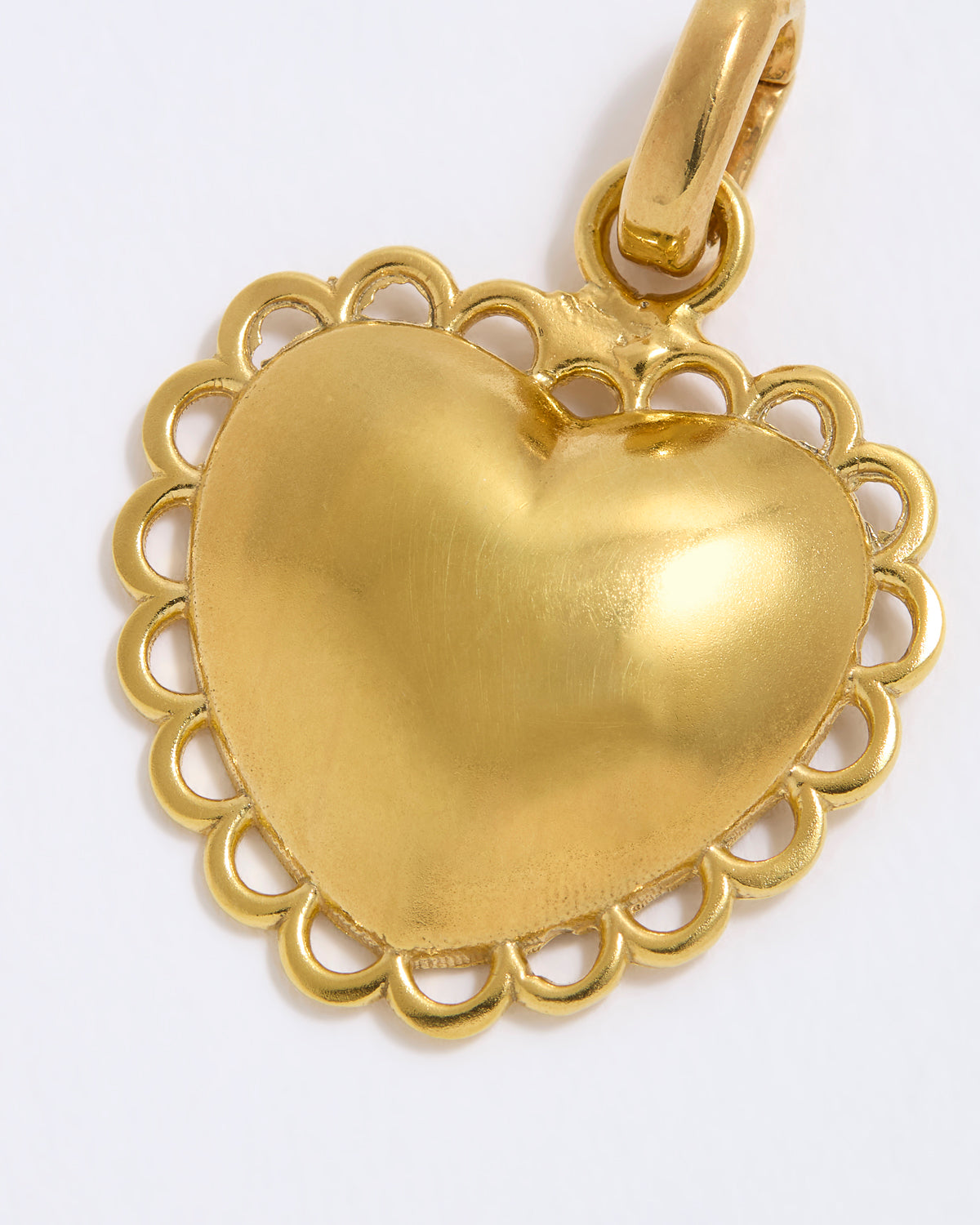 Gold heart-shaped pendant on a white background