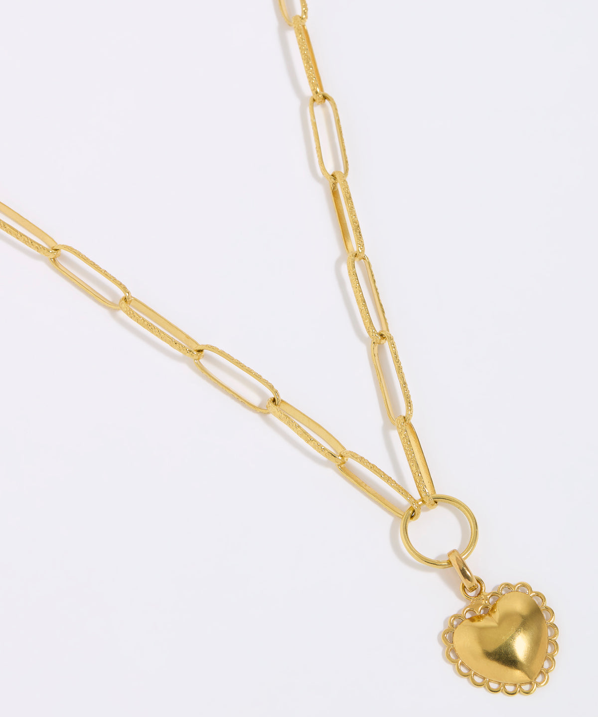 Gold heart-shaped pendant on a gold chain against a white background