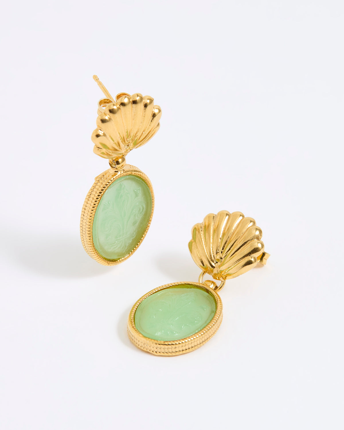 Gold shell earrings with green stones on a white background