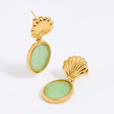 Gold shell earrings with green stones on a white background