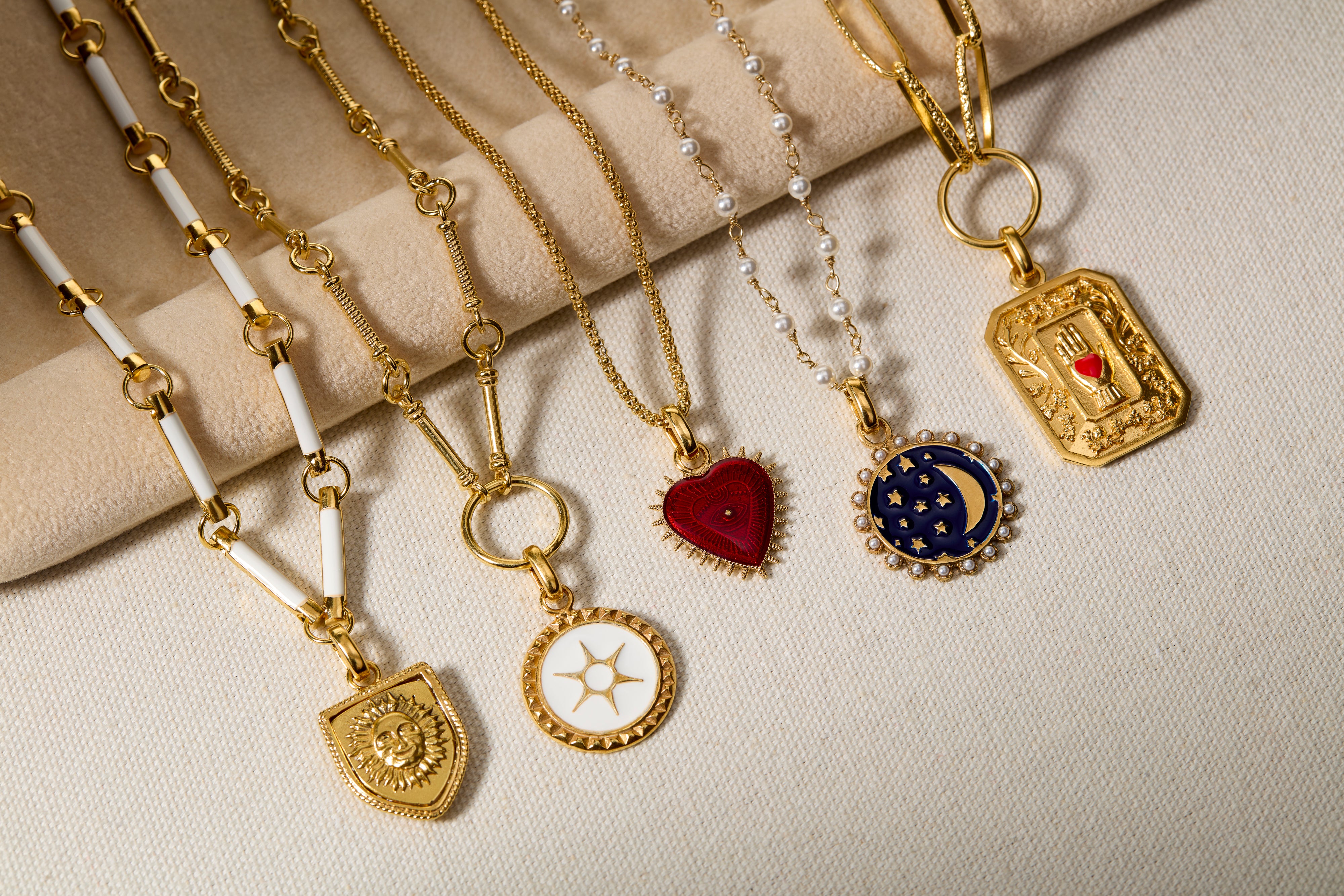 Shot of charm necklaces in a row on a beige background