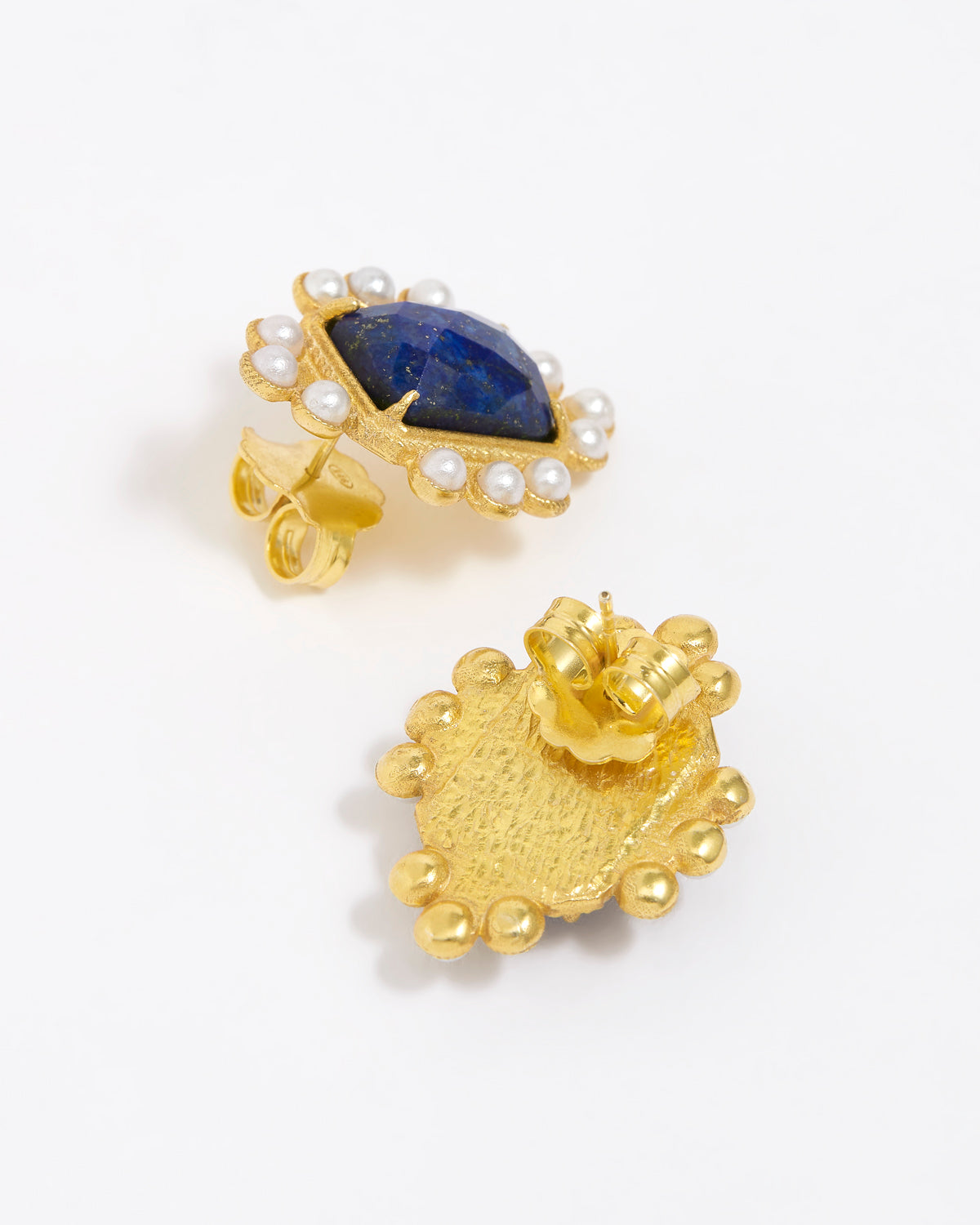 Close up of side and reverse product shot of gold earrings featuring lapis central stone and embellished with pearl accents on a white background