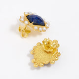 Close up of side and reverse product shot of gold earrings featuring lapis central stone and embellished with pearl accents on a white background