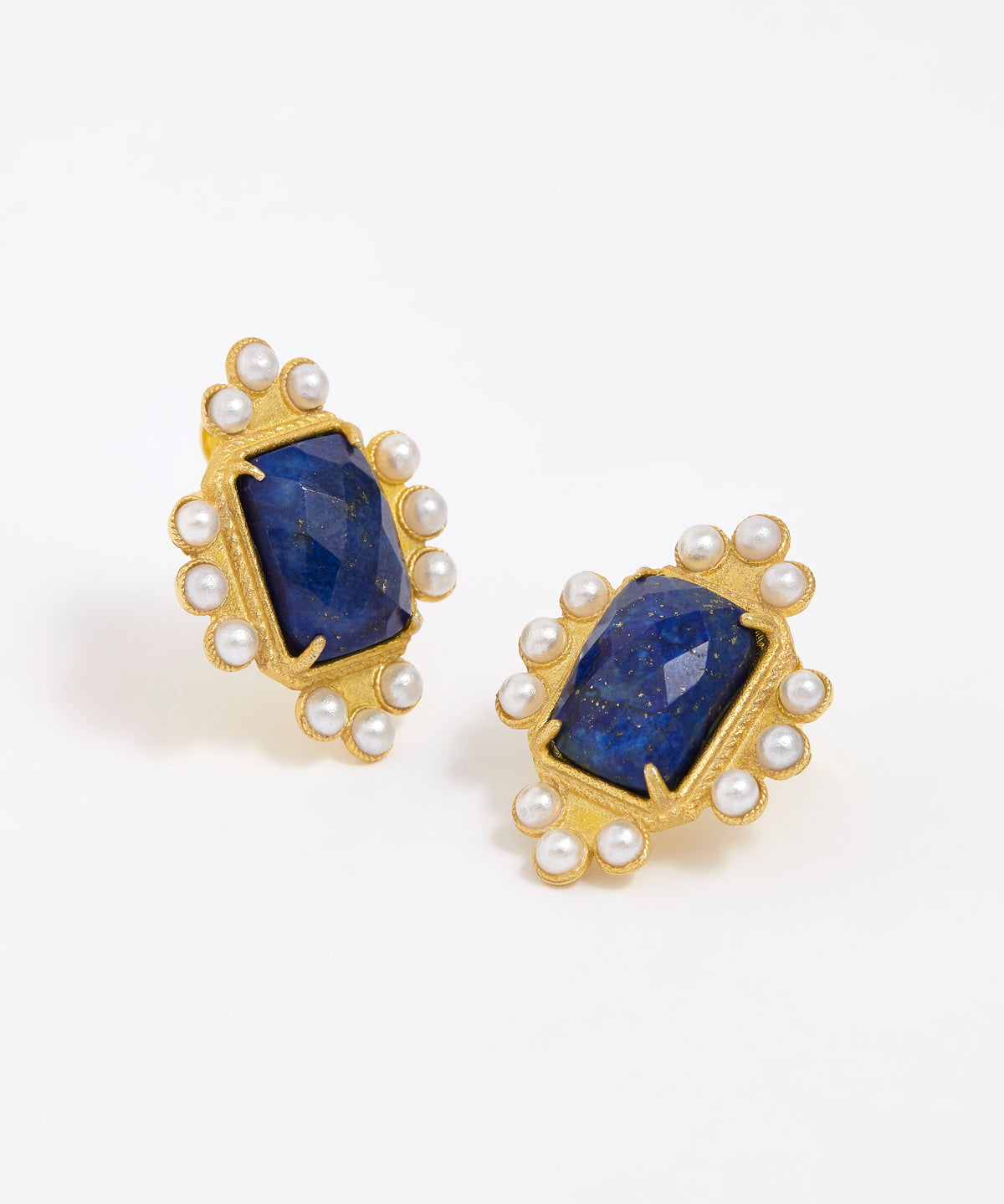 Close up product shot of gold earrings featuring lapis central stone and embellished with pearl accents on a white background