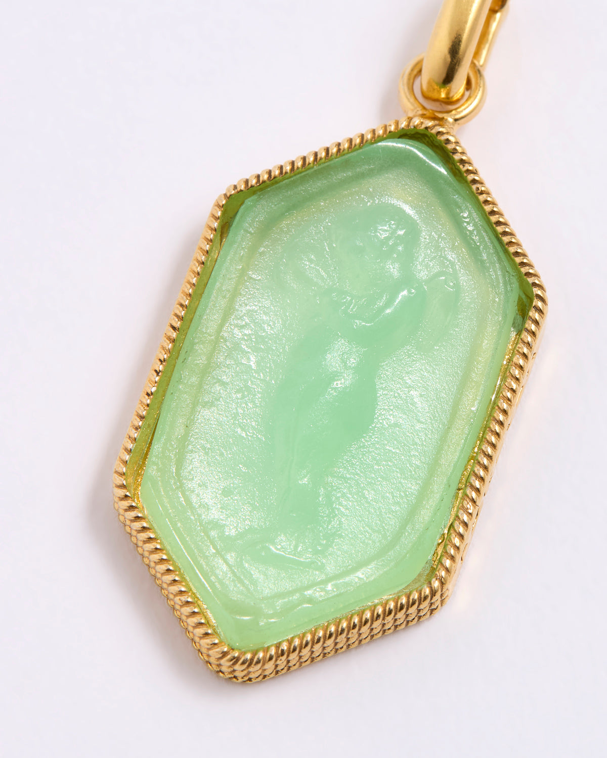 Green stone pendant with gold frame on white background