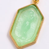 Green stone pendant with gold frame on white background