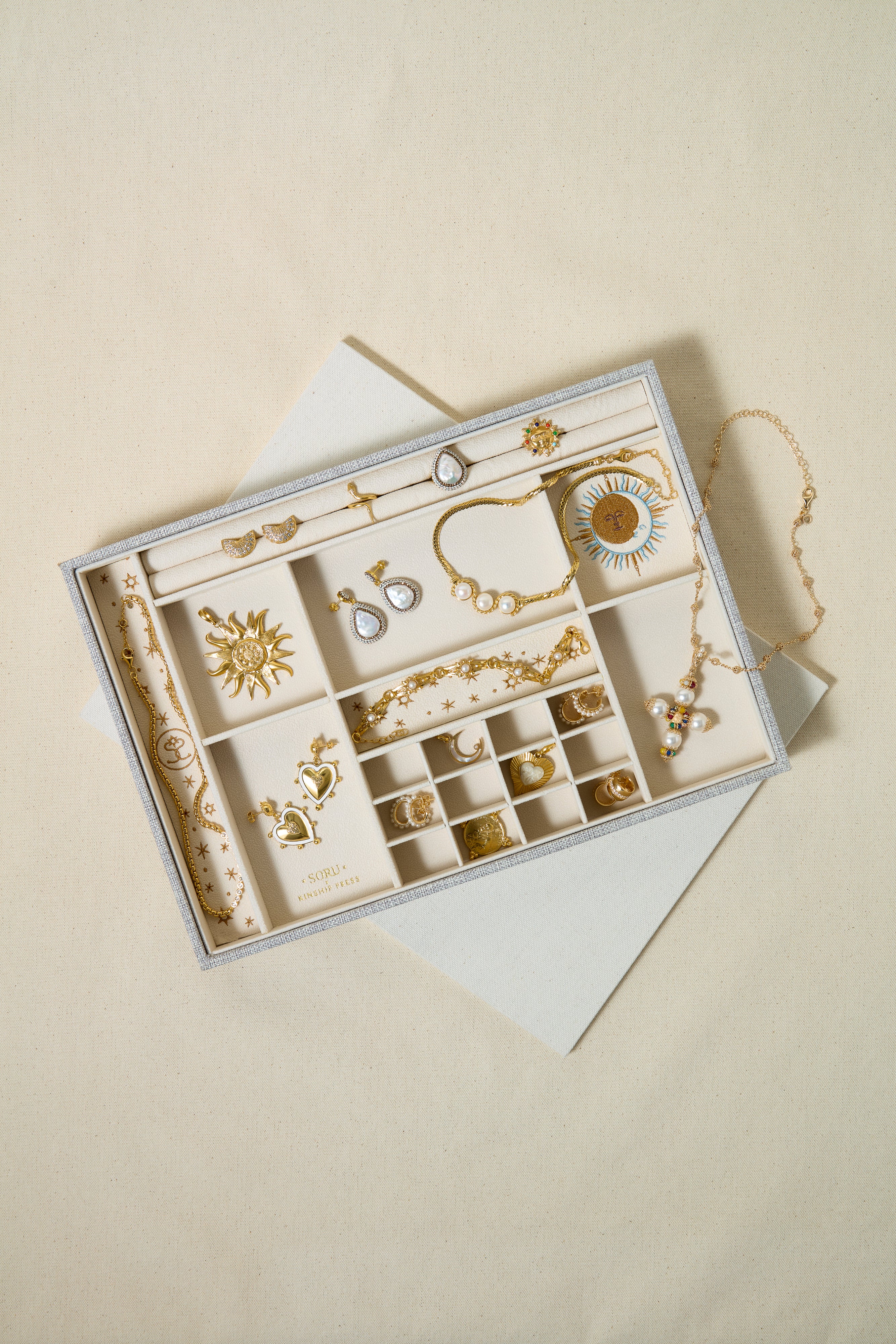 Jewelry set in an open box on a beige background