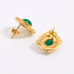 A reverse and side image of a pair of gold earrings with oval green cabochon stones, shown on a white background.