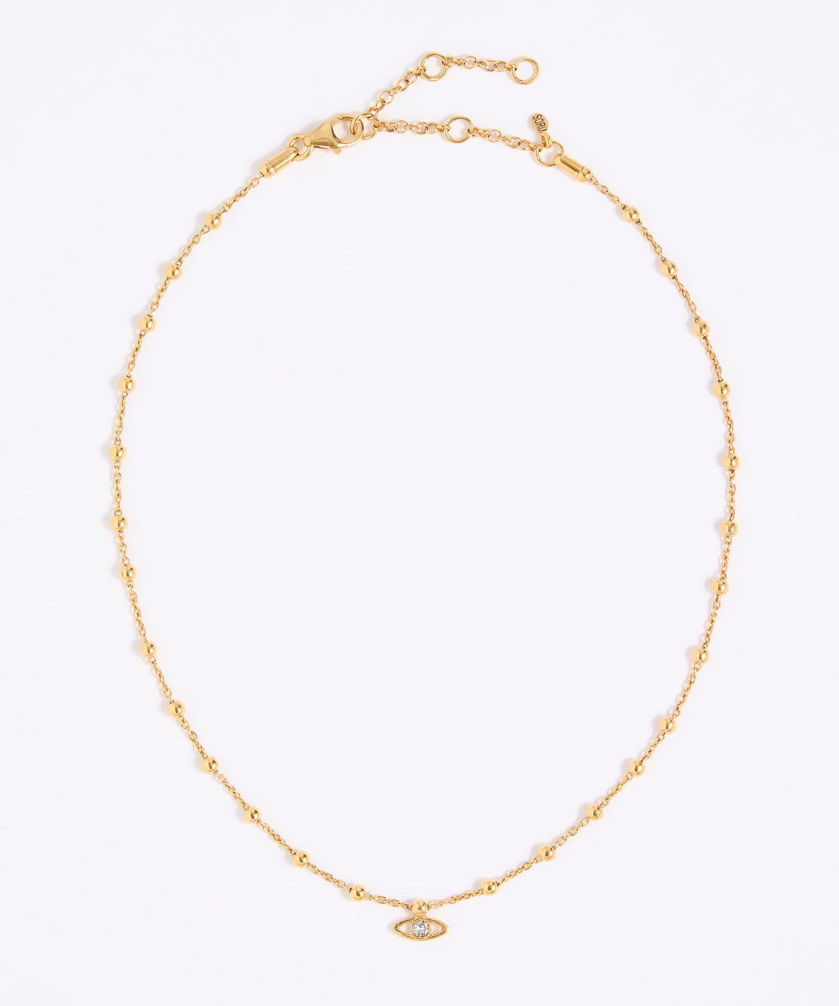 Gold coloured necklace with a small eye pendant on a white background