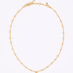Gold coloured necklace with a small eye pendant on a white background
