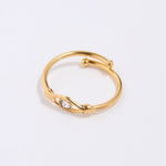 Gold coloured ring with a clear crystal at the centre of an evil eye on a light gray background