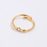 Gold coloured ring with a clear crystal at the centre of an evil eye on a light gray background