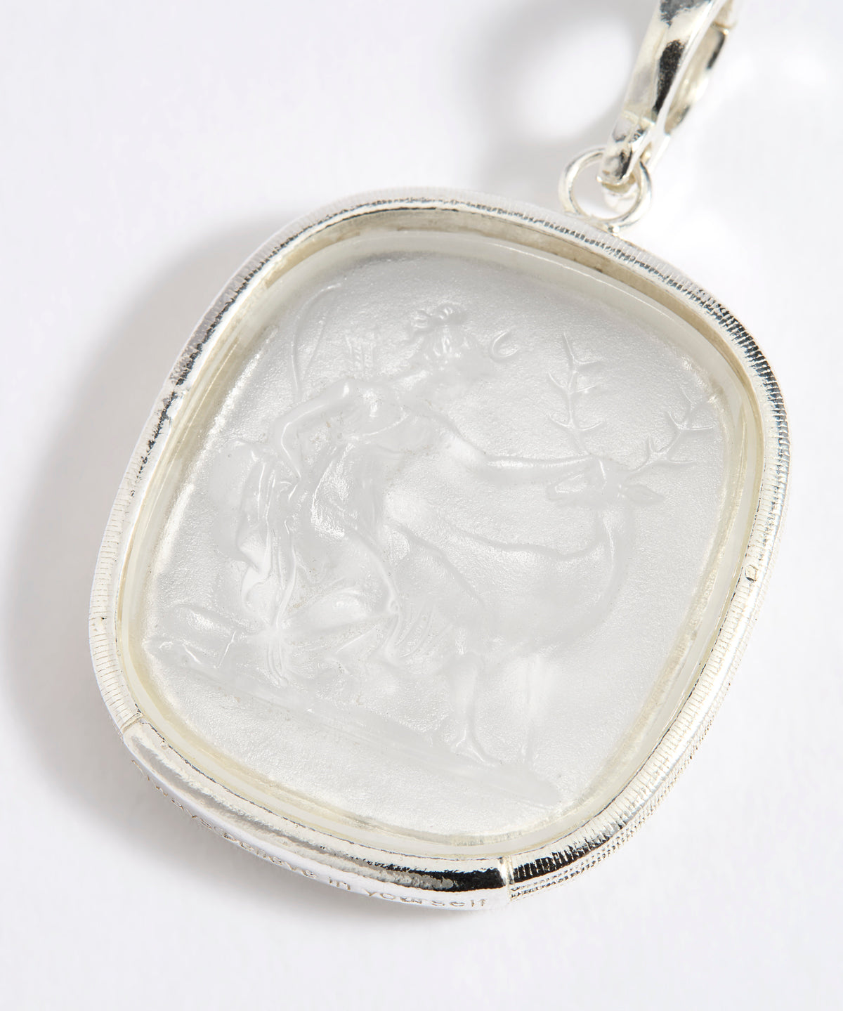 Close up of silver charm with embossed goddess Diana
