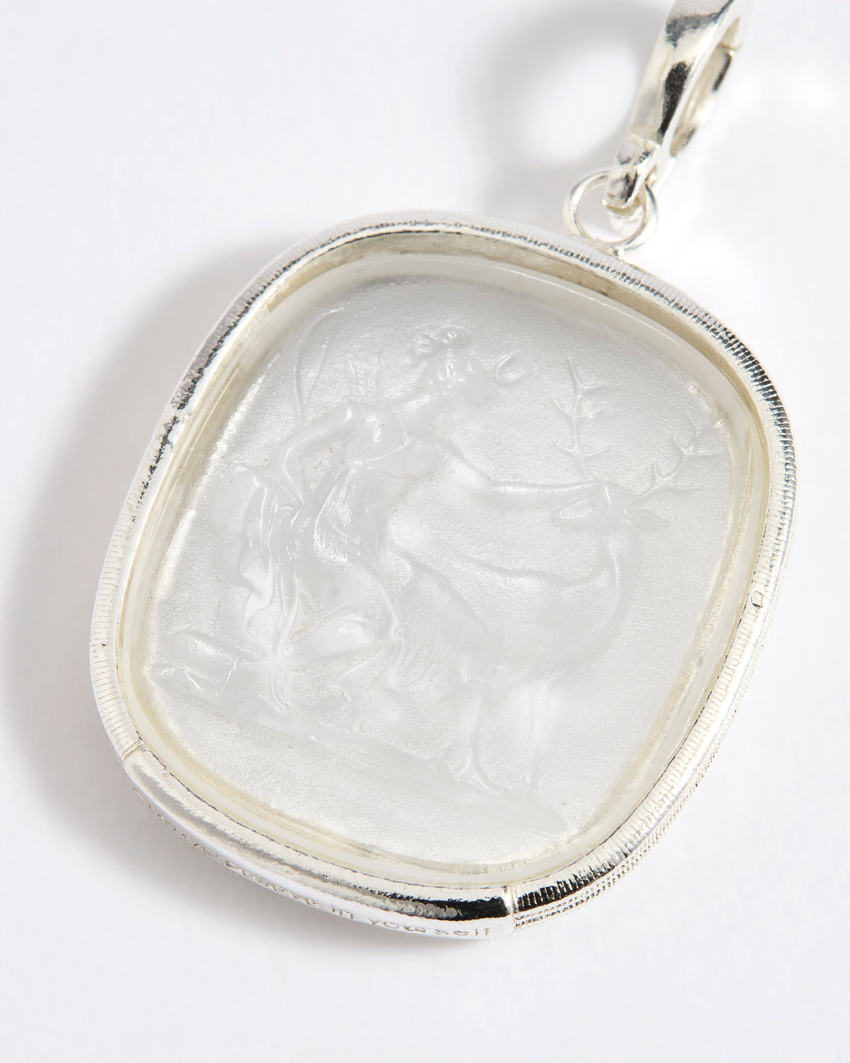 Close up of silver charm with embossed goddess Diana