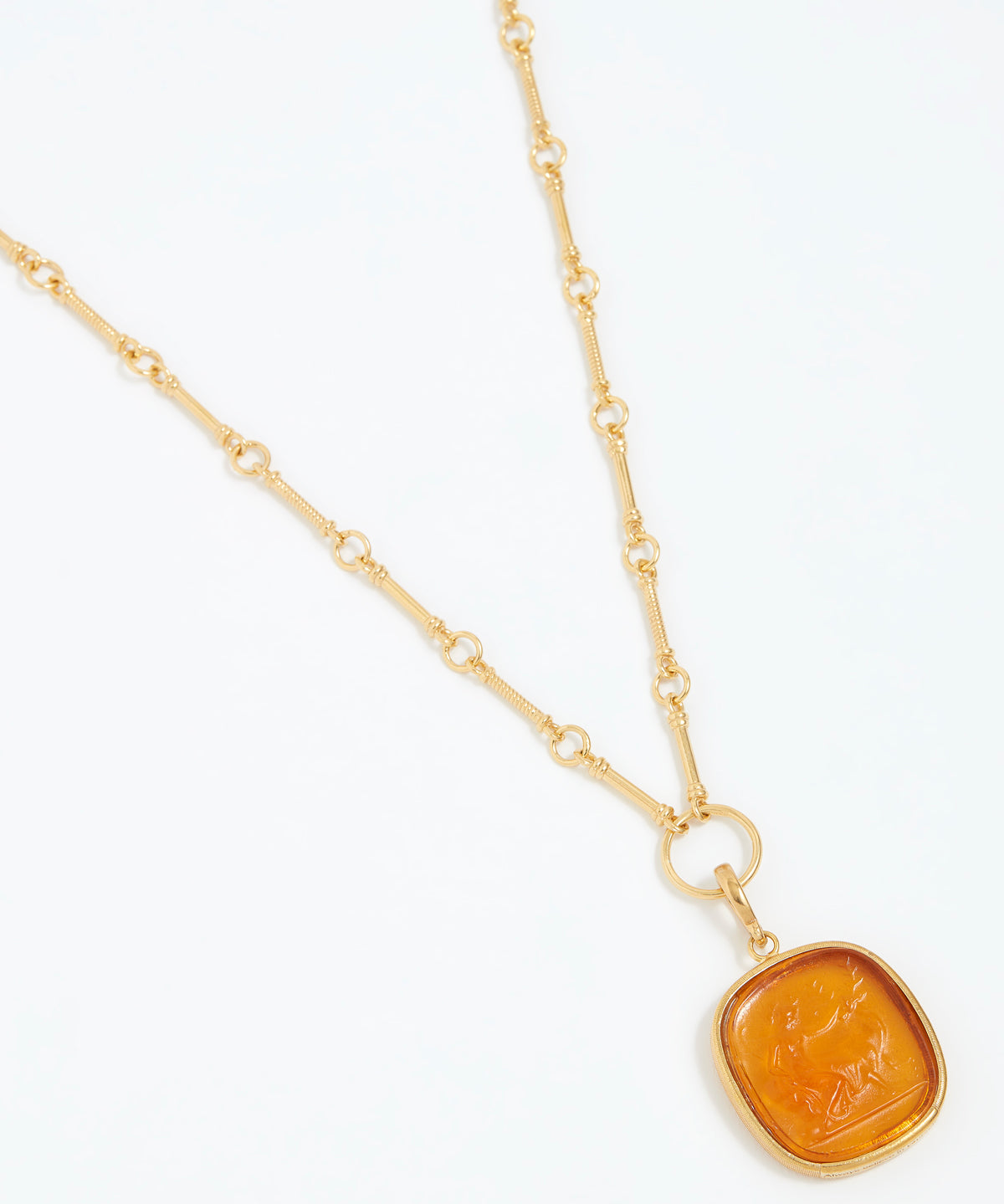 Gold necklace with a yellow stone pendant on a white background