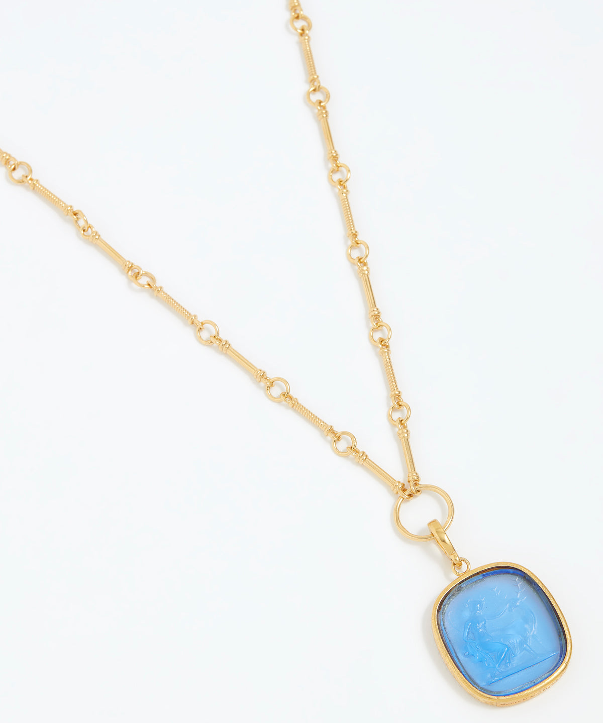 Gold necklace with a blue pendant on a white background