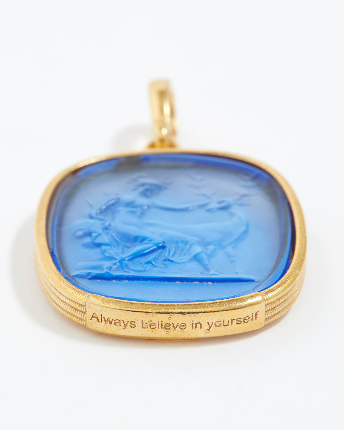 Gold pendant with blue stone and 'Always believe in yourself' engraving on a white background