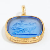 Gold pendant with blue stone and 'Always believe in yourself' engraving on a white background