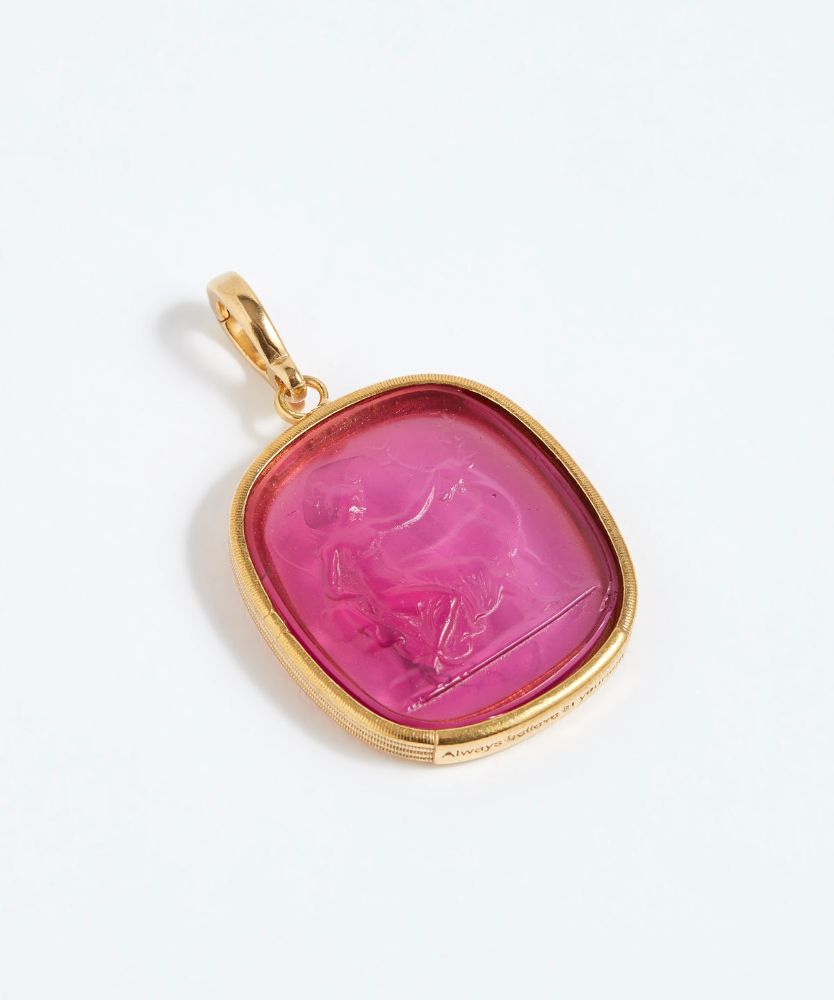 Gold pendant with a pink stone on a white background
