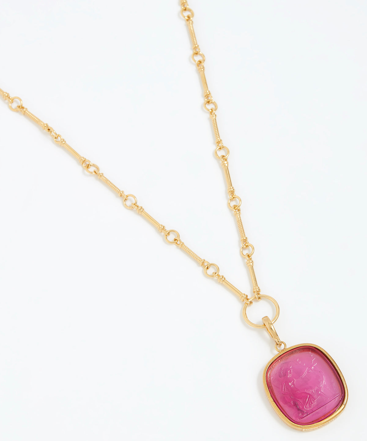 Gold necklace with a pink pendant on a white background