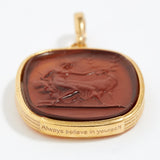 Gold pendant with a brown stone featuring an engraved design "always believe in yourself" on a white background.