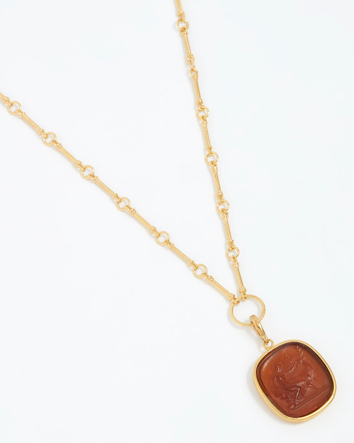 Gold necklace with a brown pendant on a white background