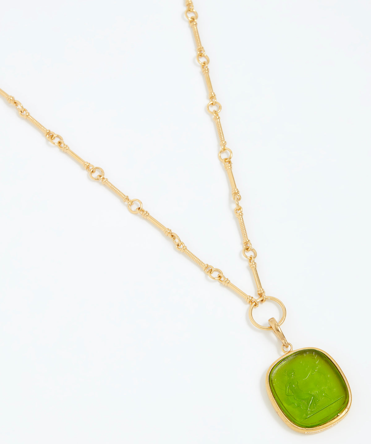 Gold necklace with a green pendant on a white background