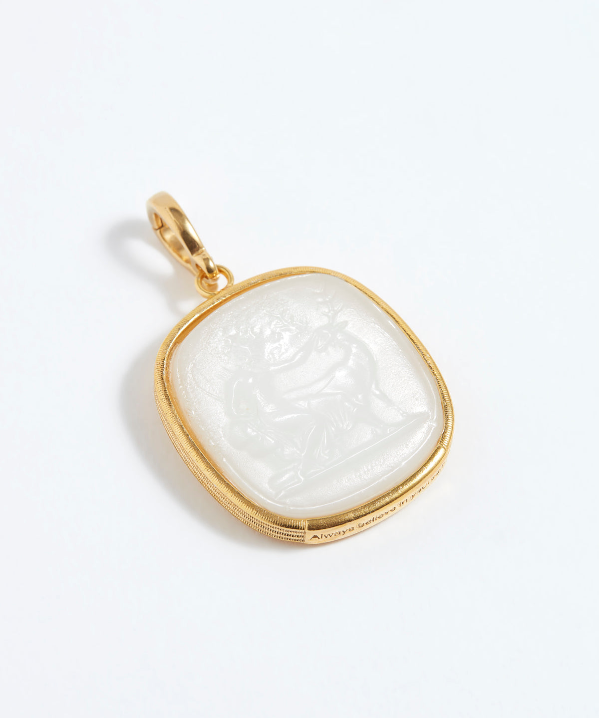 Gold pendant with a white stone on a light gray background