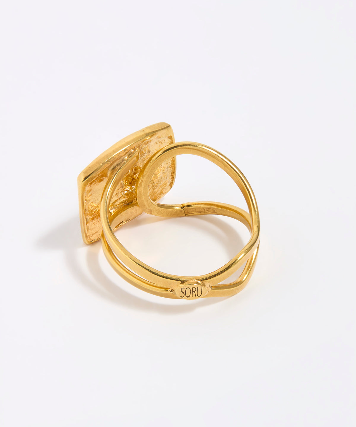 Gold ring with a textured design on a white background