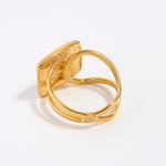 Gold ring with a textured design on a white background