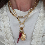 Image of soru charm chain with madonna pendant and red cornucopia pendant charm  and soru scomo necklace around a neck